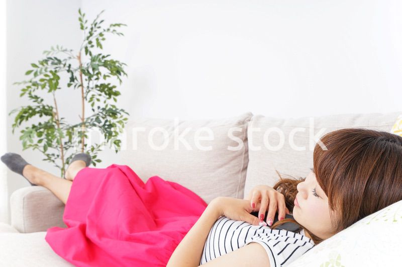 ソファで寝る若い女性