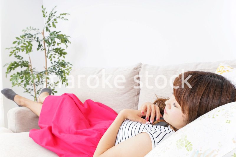 ソファで寝る若い女性