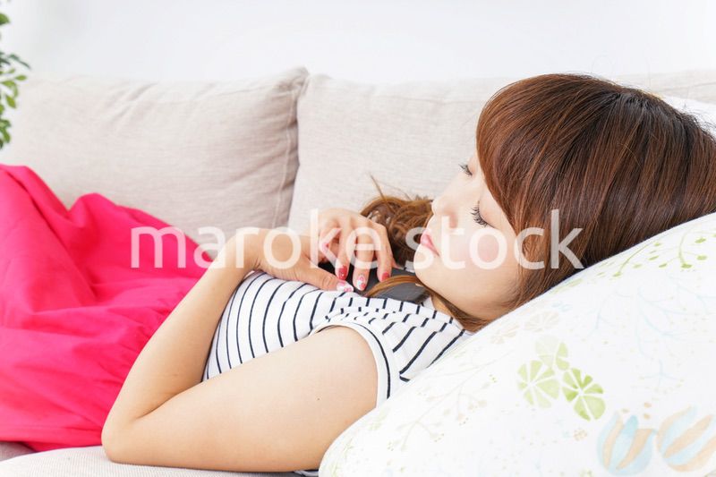 ソファで寝る若い女性