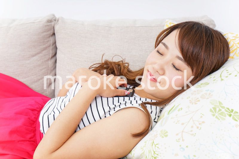 ソファで寝る若い女性