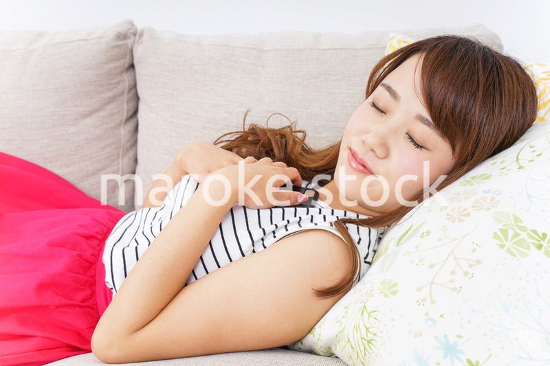 ソファで寝る若い女性