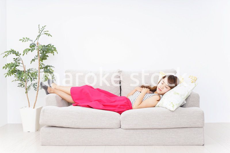 ソファで寝る若い女性