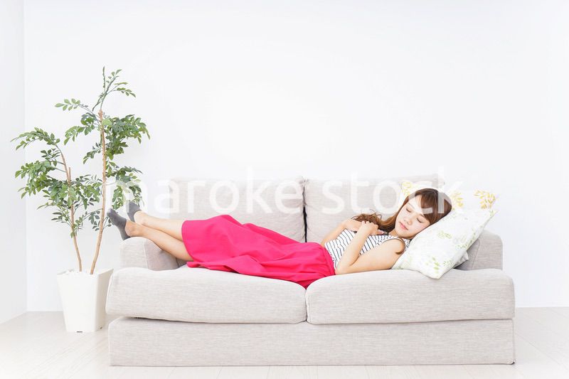 ソファで寝る若い女性