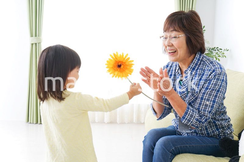 祖母に花をあげる子ども
