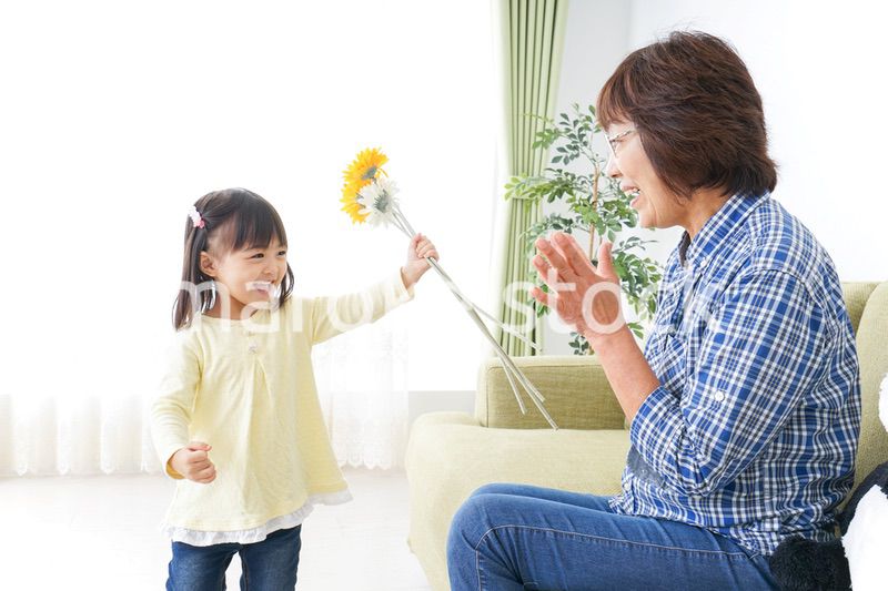祖母に花をあげる子ども