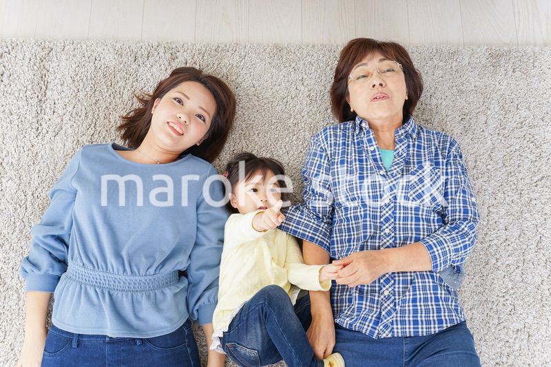 部屋で寝転ぶ子供と母とおばあちゃん