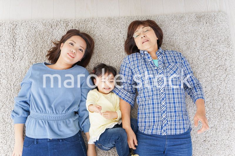 部屋で寝転ぶ子供と母とおばあちゃん
