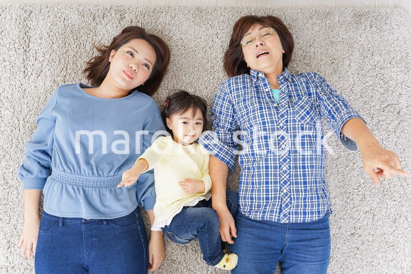 部屋で寝転ぶ子供と母とおばあちゃん
