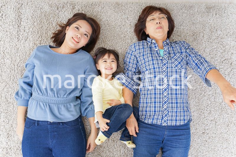 部屋で寝転ぶ子供と母とおばあちゃん