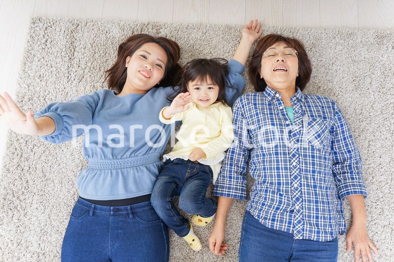 部屋で寝転ぶ子供と母とおばあちゃん
