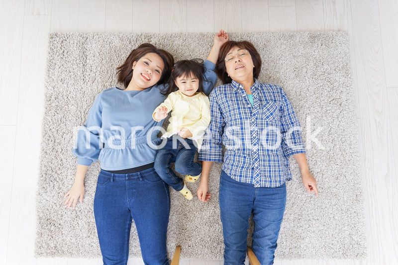 部屋で寝転ぶ子供と母とおばあちゃん