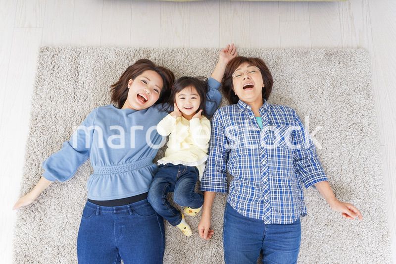 部屋で寝転ぶ子供と母とおばあちゃん
