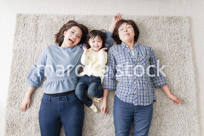 部屋で寝転ぶ子供と母とおばあちゃん