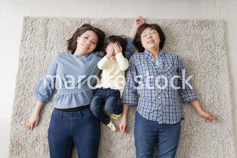 部屋で寝転ぶ子供と母とおばあちゃん