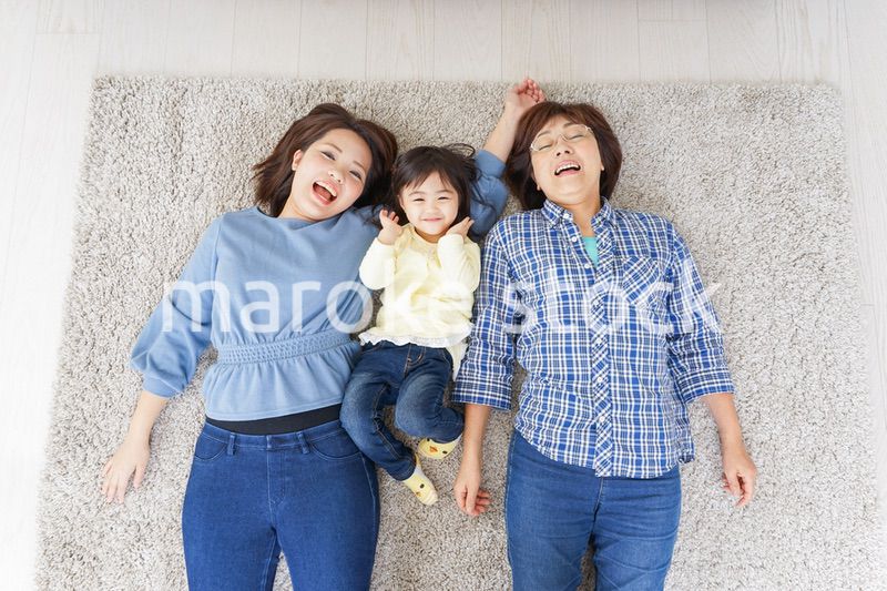 部屋で寝転ぶ子供と母とおばあちゃん