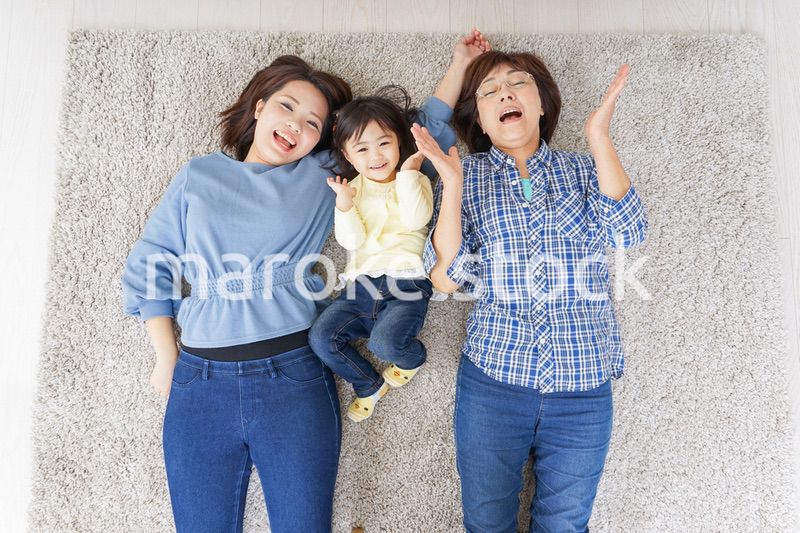 部屋で寝転ぶ子供と母とおばあちゃん