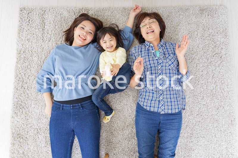 部屋で寝転ぶ子供と母とおばあちゃん