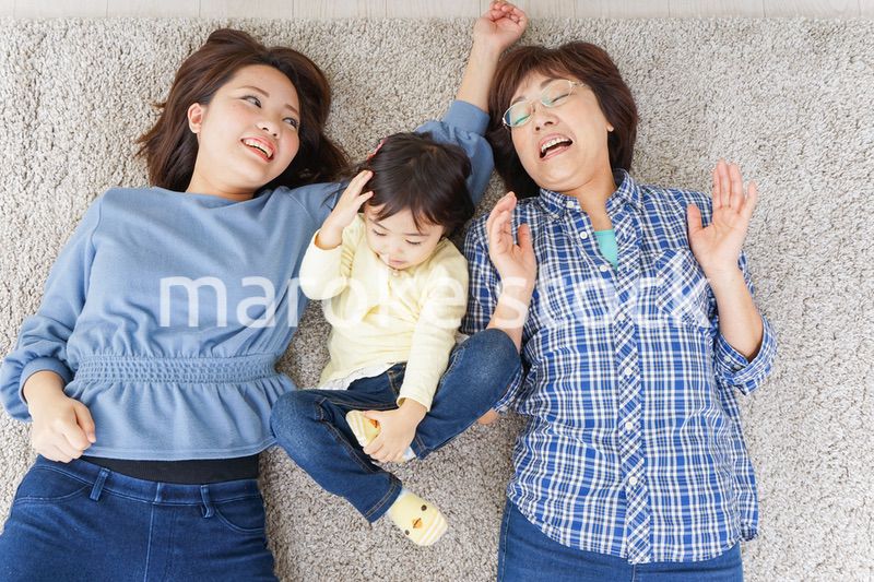 部屋で寝転ぶ子供と母とおばあちゃん
