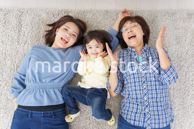 部屋で寝転ぶ子供と母とおばあちゃん