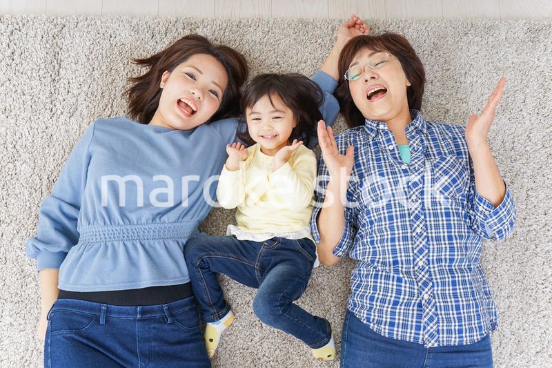 部屋で寝転ぶ子供と母とおばあちゃん