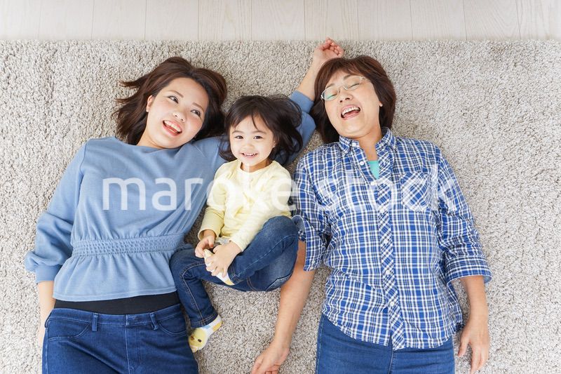 部屋で寝転ぶ子供と母とおばあちゃん