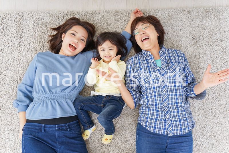 部屋で寝転ぶ子供と母とおばあちゃん