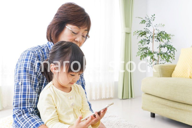おばあちゃんとスマホを使う子供