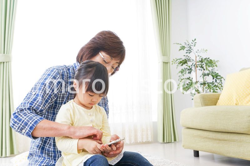 おばあちゃんとスマホを使う子供