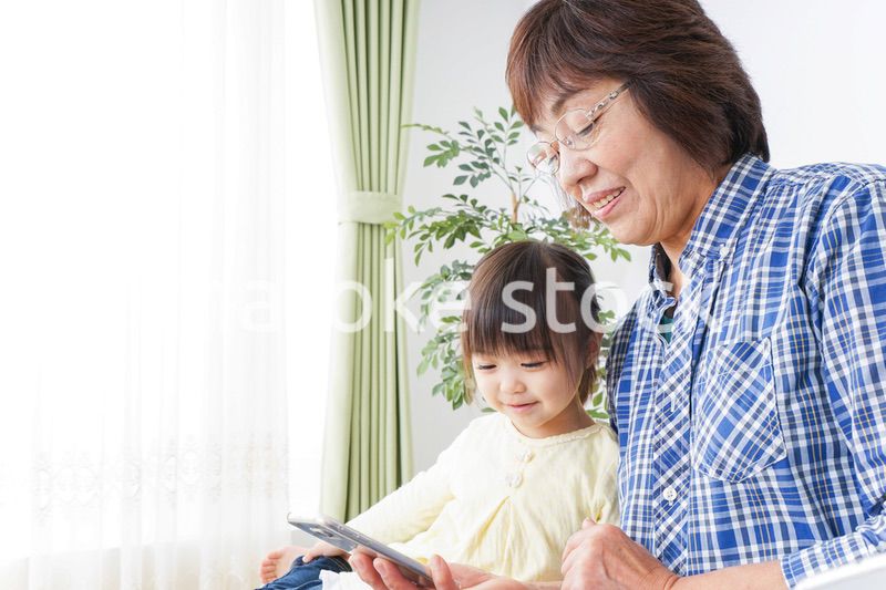 おばあちゃんとスマホを使う子供