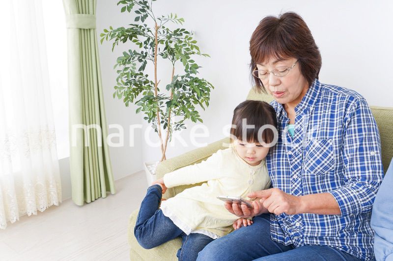 おばあちゃんとスマホを使う子供
