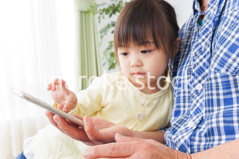 おばあちゃんとスマホを使う子供