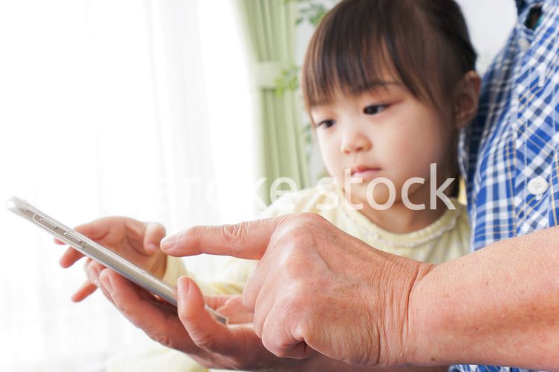 おばあちゃんとスマホを使う子供