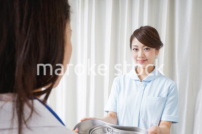 医師に道具を渡す看護師