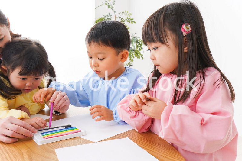 お絵かきをする子どもたちと保育士