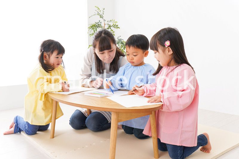 お絵かきをする子どもたちと保育士