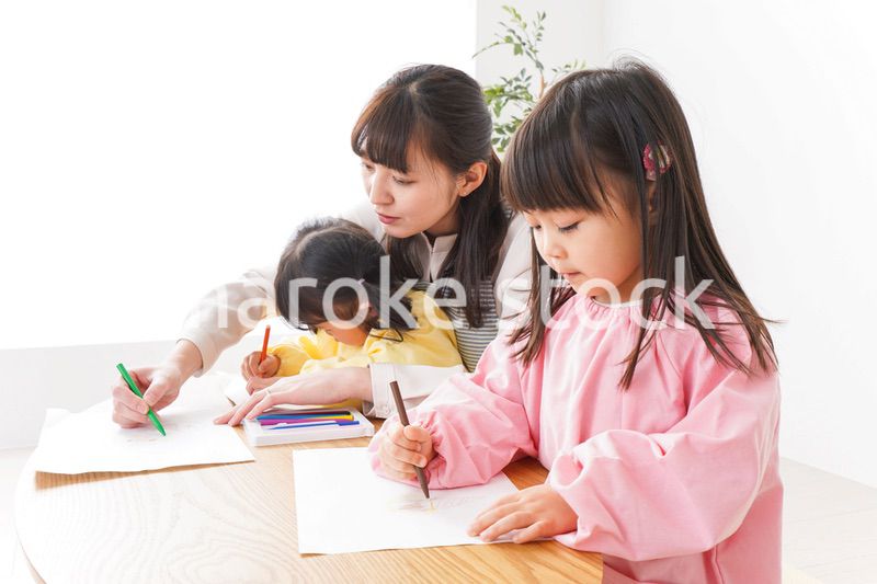 お絵かきをする子どもたちと保育士