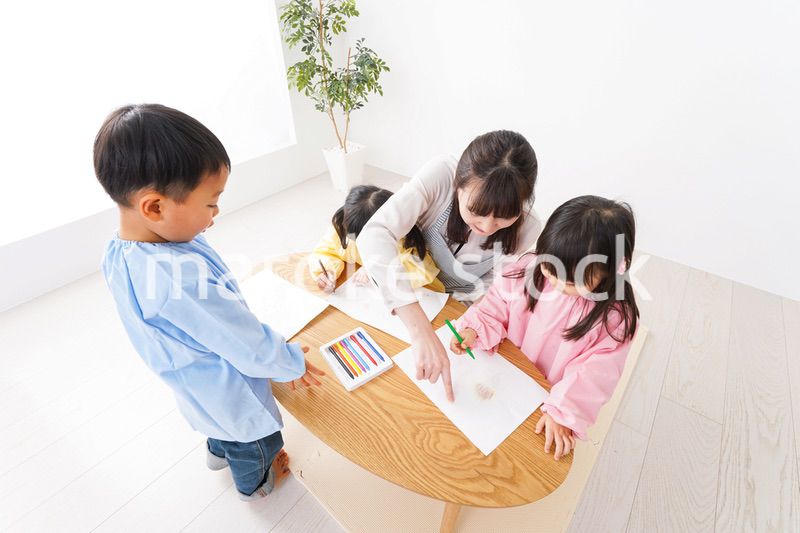 お絵かきをする子どもたちと保育士