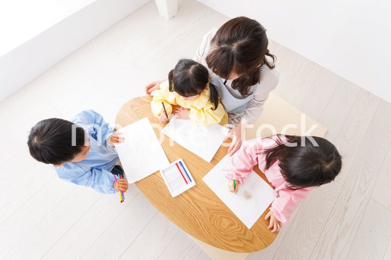 お絵かきをする子どもたちと保育士