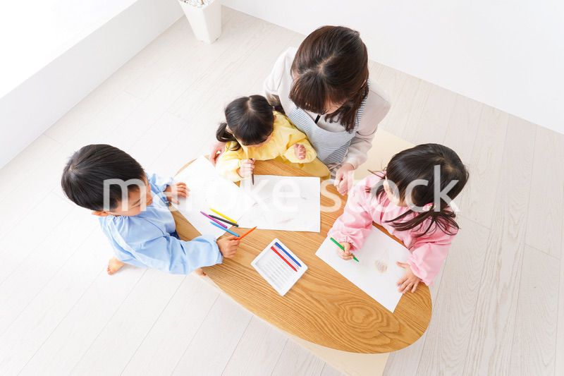 お絵かきをする子どもたちと保育士