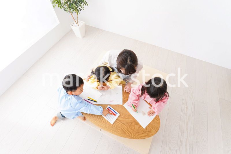 お絵かきをする子どもたちと保育士