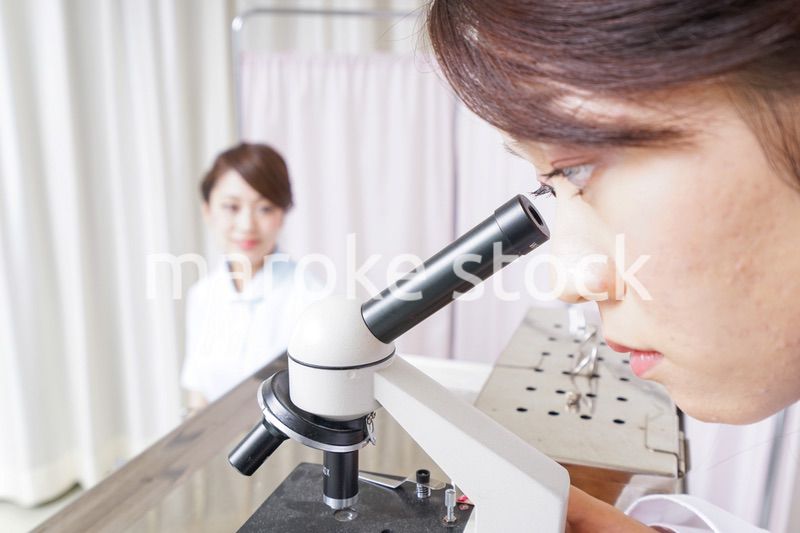 顕微鏡を見る医師と看護師