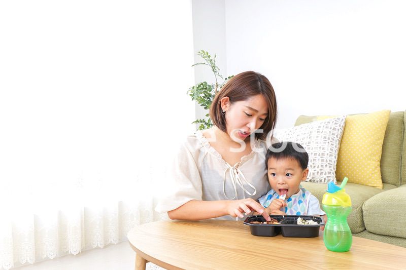 子どもにごはんを食べさせる母親