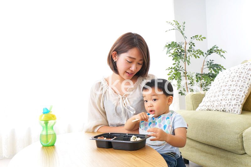 子どもにごはんを食べさせる母親