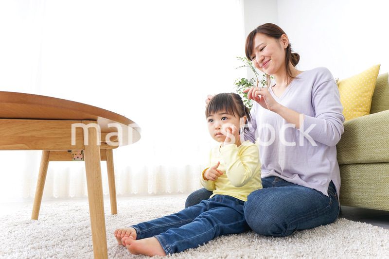 子どもの髪の毛を結ぶお母さん