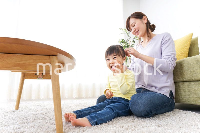子どもの髪の毛を結ぶお母さん