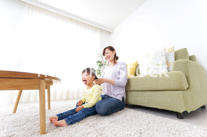 子どもの髪の毛を結ぶお母さん