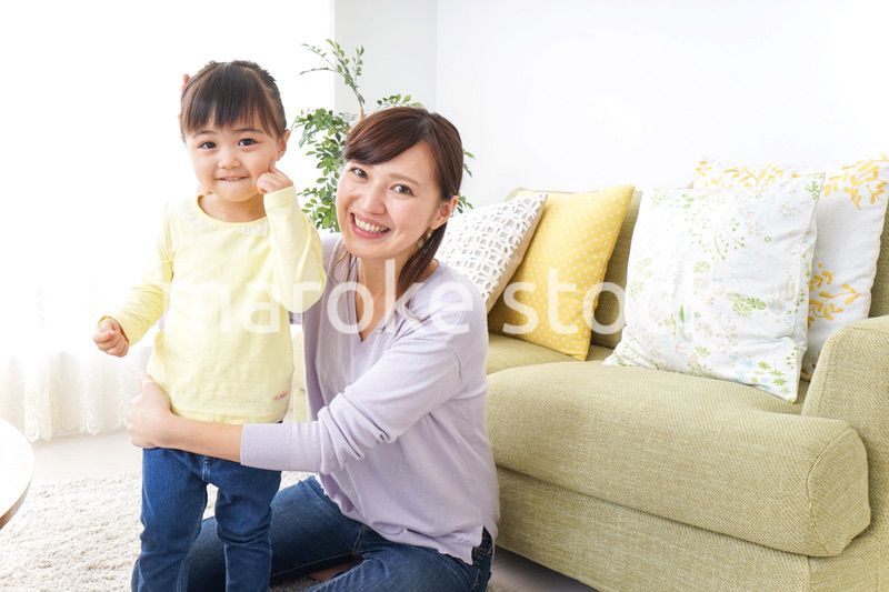 子どもの髪の毛を結ぶお母さん