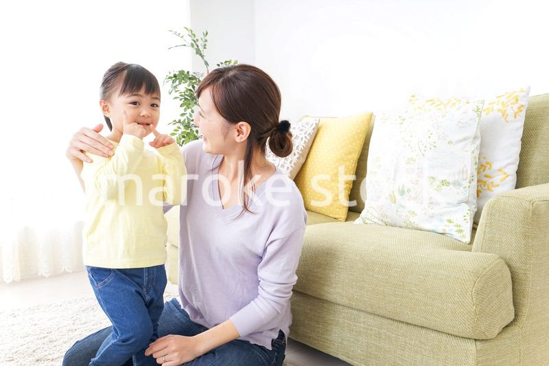 子どもの髪の毛を結ぶお母さん