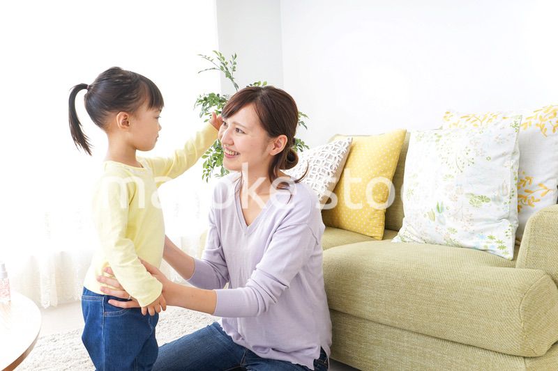 子どもの髪の毛を結ぶお母さん