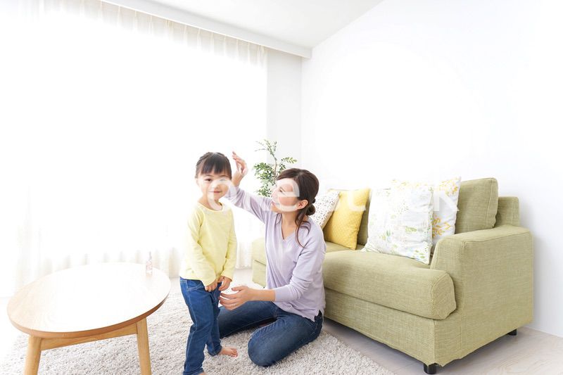 子どもの髪の毛を結ぶお母さん